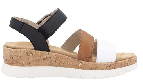 Womens sandal with cork wedge heel and black, tan, and white straps.