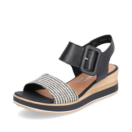 Black sandal with an ankle strap and buckle. The toe strap is white and black.