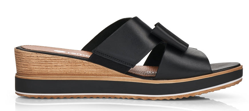 A black sandal with a wedge heel and crisscross straps.