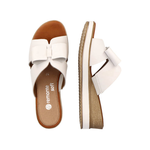 Pair of white platform sandals with bow, one showing sole, other showing upper.