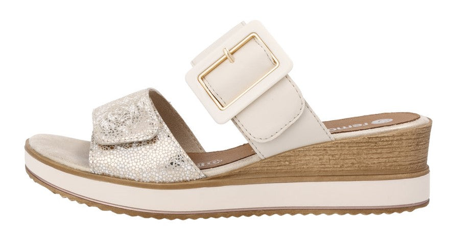 Side view of a sandal with a wedge heel, featuring an ivory strap with a gold buckle and a gold and white patterned strap.