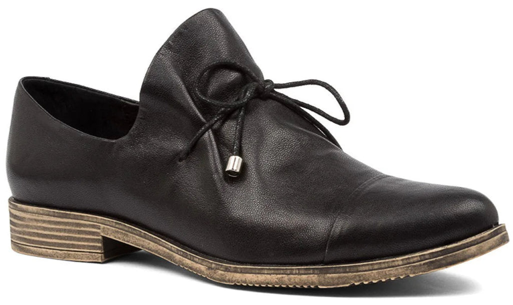 A dark colored flat dress shoe with tie closure.