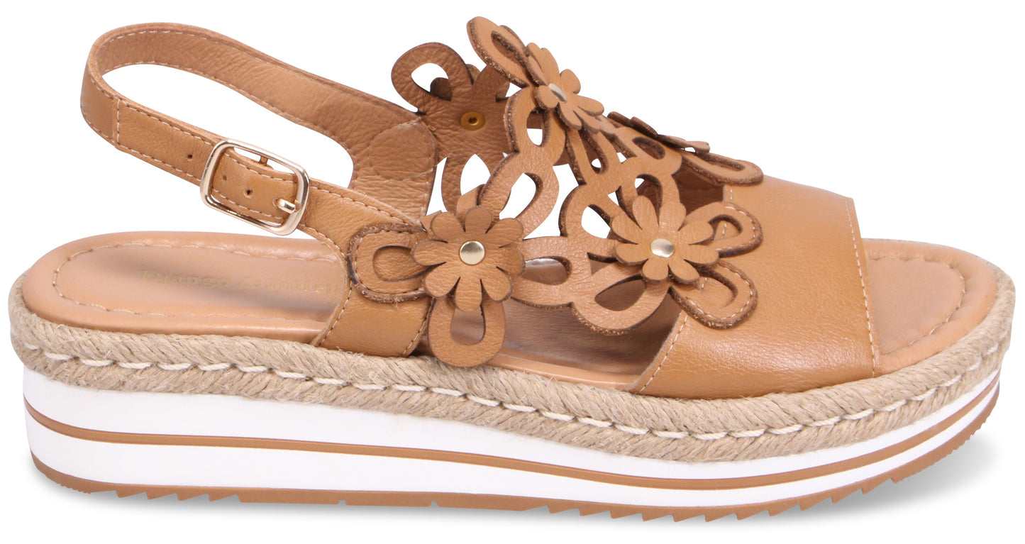 Tan platform sandal with floral accents and adjustable ankle strap.