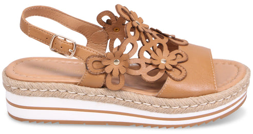 Tan platform sandal with floral accents and adjustable ankle strap.