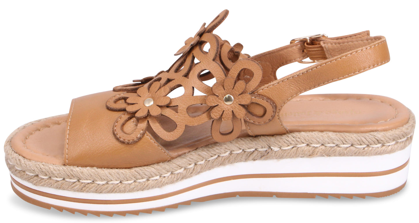 Tan platform sandal with flower cutouts and ankle strap.