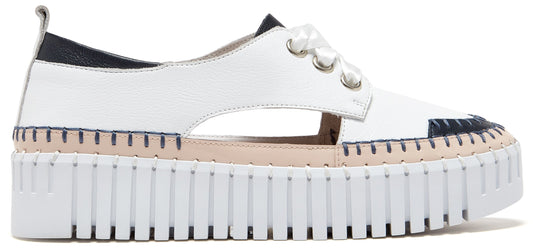 A white platform shoe with cut-out sides and navy and white accents.