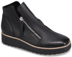 A black leather ankle boot with a slanted, silver-colored side zipper, a square toe, and a thick, ridged black platform sole with a thin tan-colored trim.