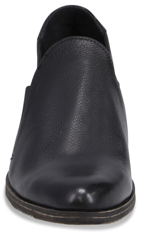 A black leather slip-on shoe with a low profile and a rounded toe, viewed from the front.