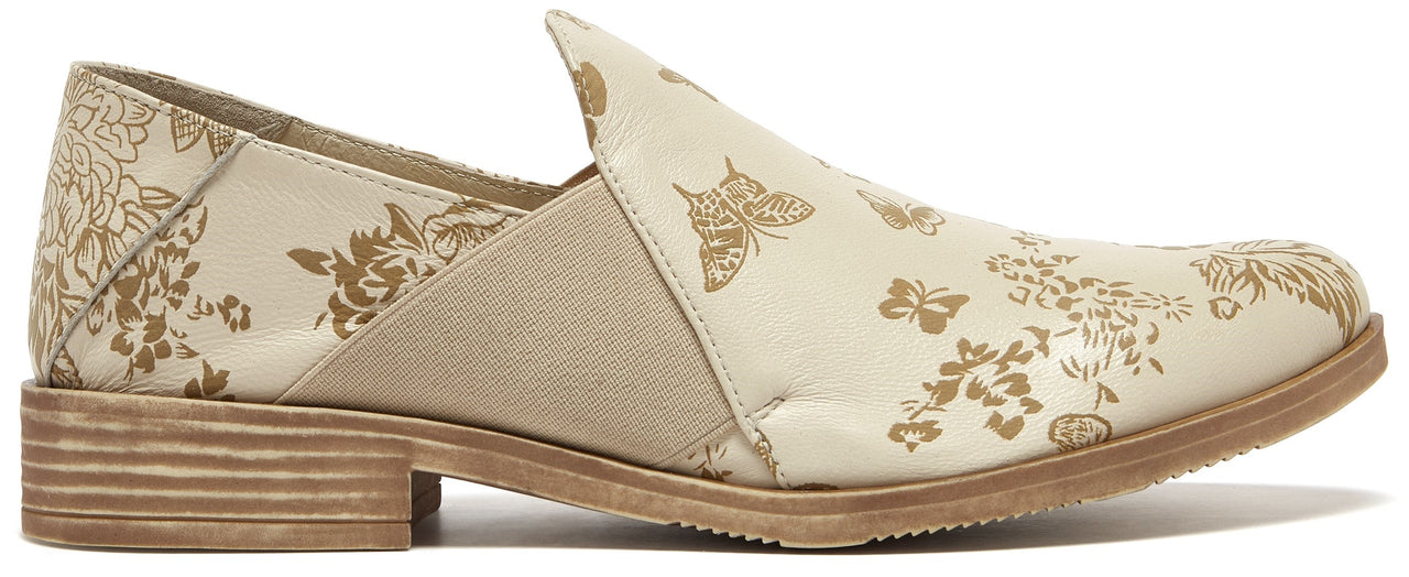 Beige slip-on shoe with floral and butterfly pattern.