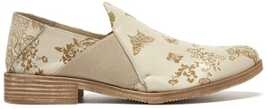 Beige slip-on shoe with floral and butterfly pattern.