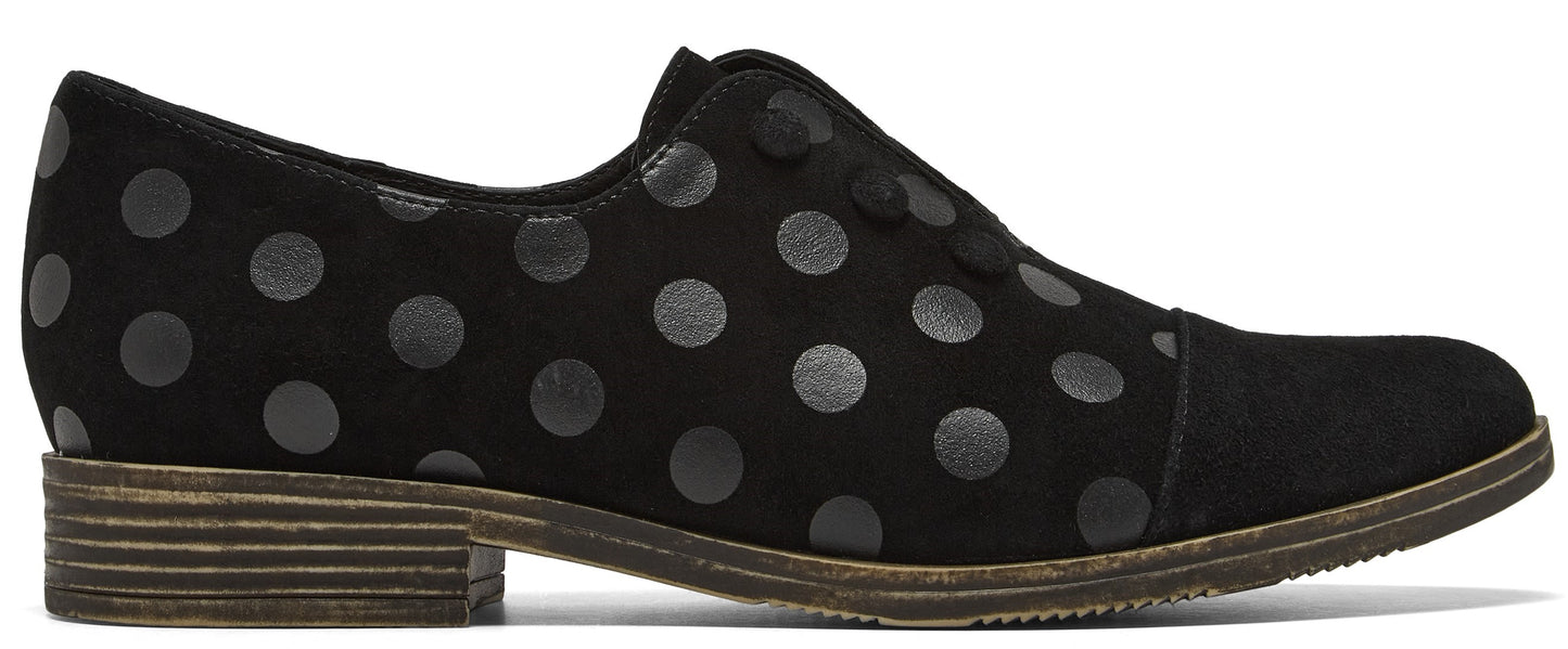 A black suede oxford shoe with a repeating dark grey polka dot pattern and a small stacked wooden heel.