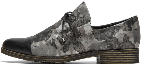 A gray and black floral pattern flat oxford shoe with a smooth black toe cap, thin black laces, and a low stacked wooden heel.