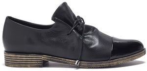 A black lace-up shoe with a patent leather toe and low stacked heel.