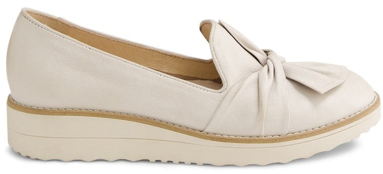 A white leather loafer with a bow.