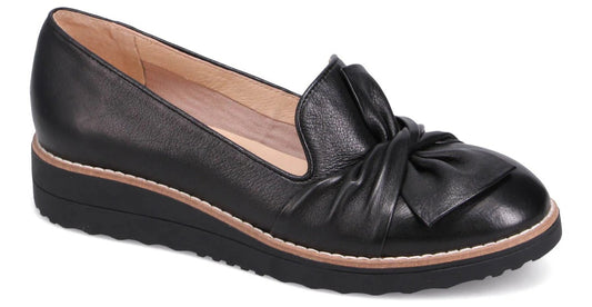 Black leather loafer with bow detail and wedge heel.