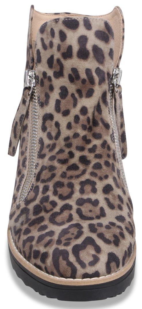 A leopard-print ankle boot with a beige base and dark brown spots, featuring silver-toned side zippers on both sides, a light beige midsole, and a thick, ridged black rubber outsole.