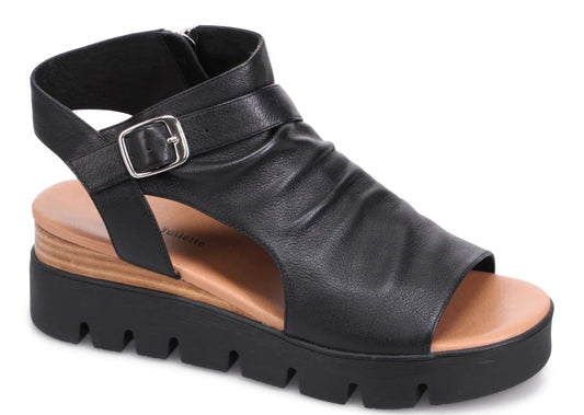 Black leather sandal with adjustable buckle ankle strap and platform lug sole.