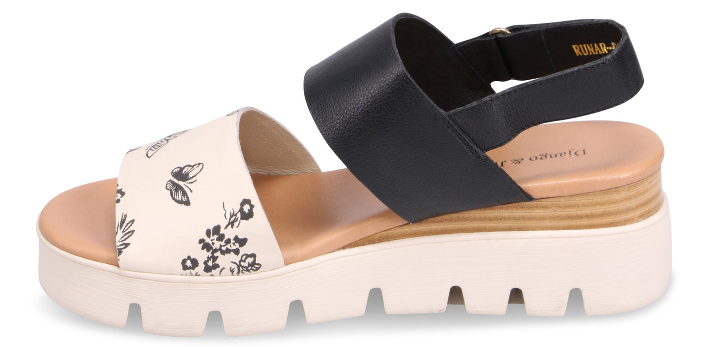 A platform sandal with a floral pattern strap and a black strap.