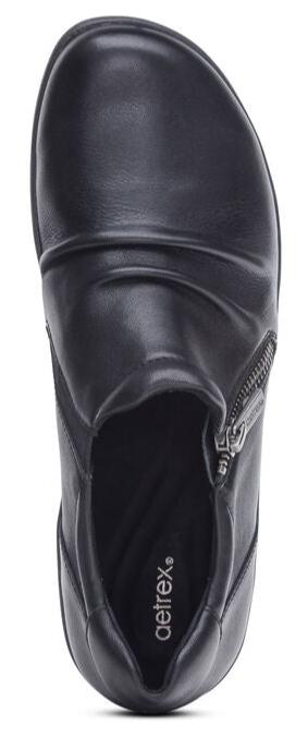 A top down view of a black leather ankle boot with a silver zipper closure.
