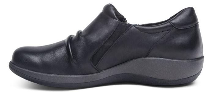 A black slip-on shoe with a low wedge heel.