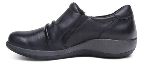 A black slip-on shoe with a low wedge heel.