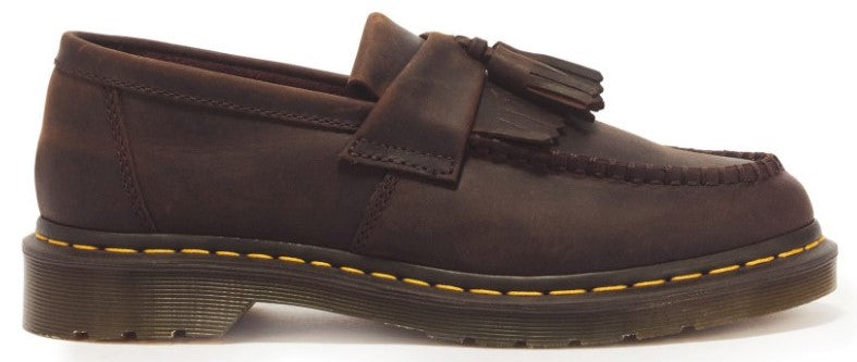 A brown leather tassel loafer shoe with moc-toe stitching and yellow welt stitching along the sole.