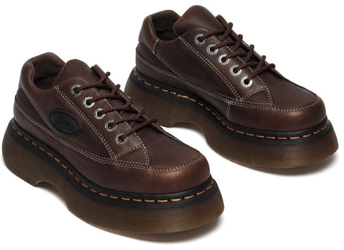 Pair of brown leather platform shoes with white stitching and silver eyelets.