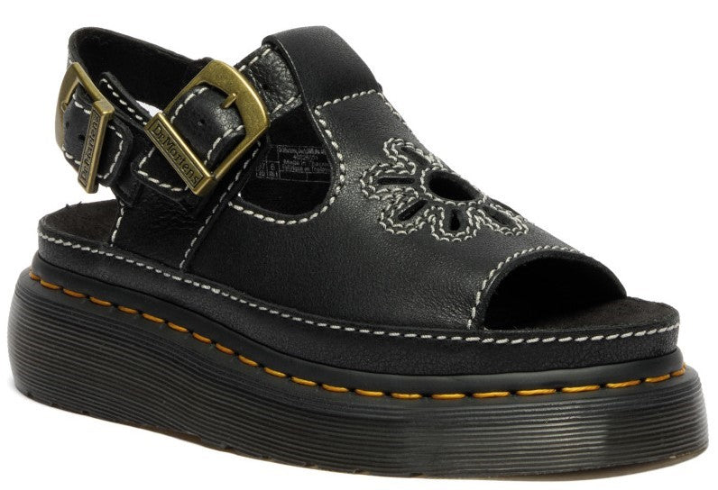 Black sandal with flower cutout, white stitching, buckled strap, and platform sole.