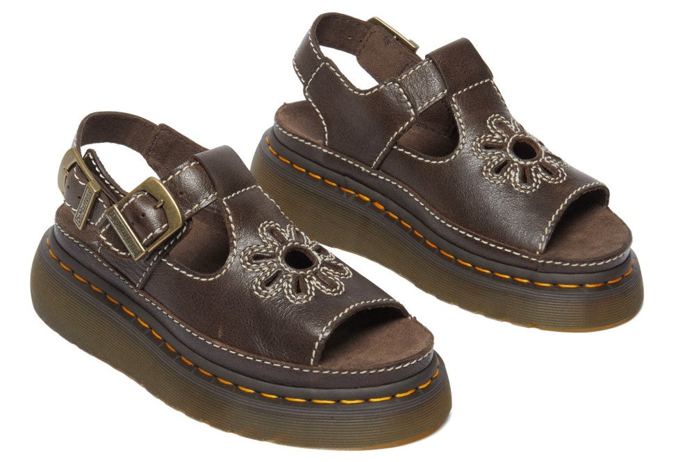 A pair of brown leather platform sandals with buckle and floral cutouts.