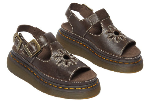 A pair of brown leather platform sandals with buckle and floral cutouts.