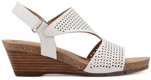 White wedge sandal with a floral cut-out design and adjustable ankle strap.