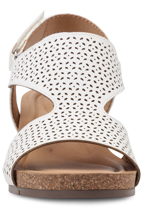 White sandal with floral laser cutouts and cork midsole.