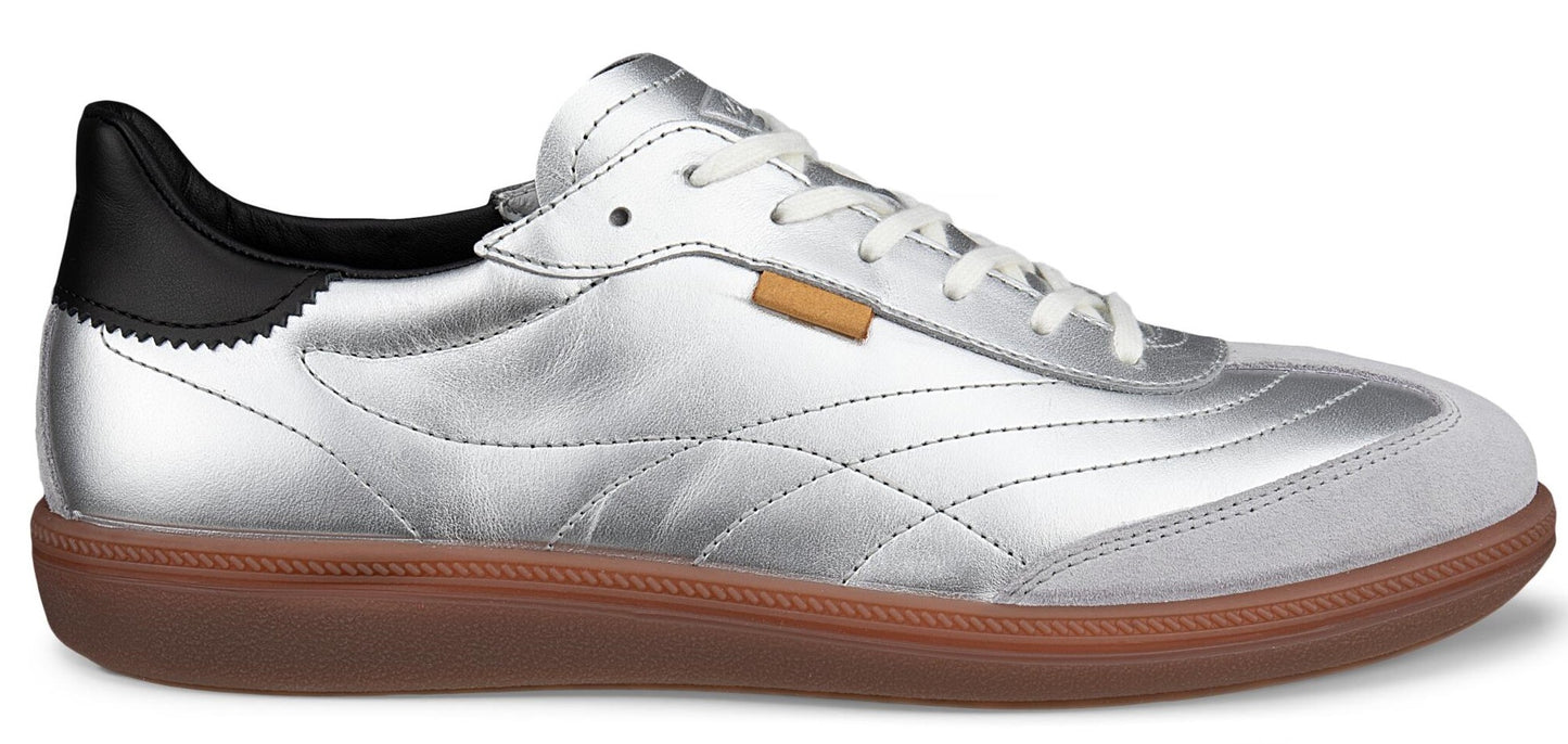 A silver shoe with a gum sole and black heel.