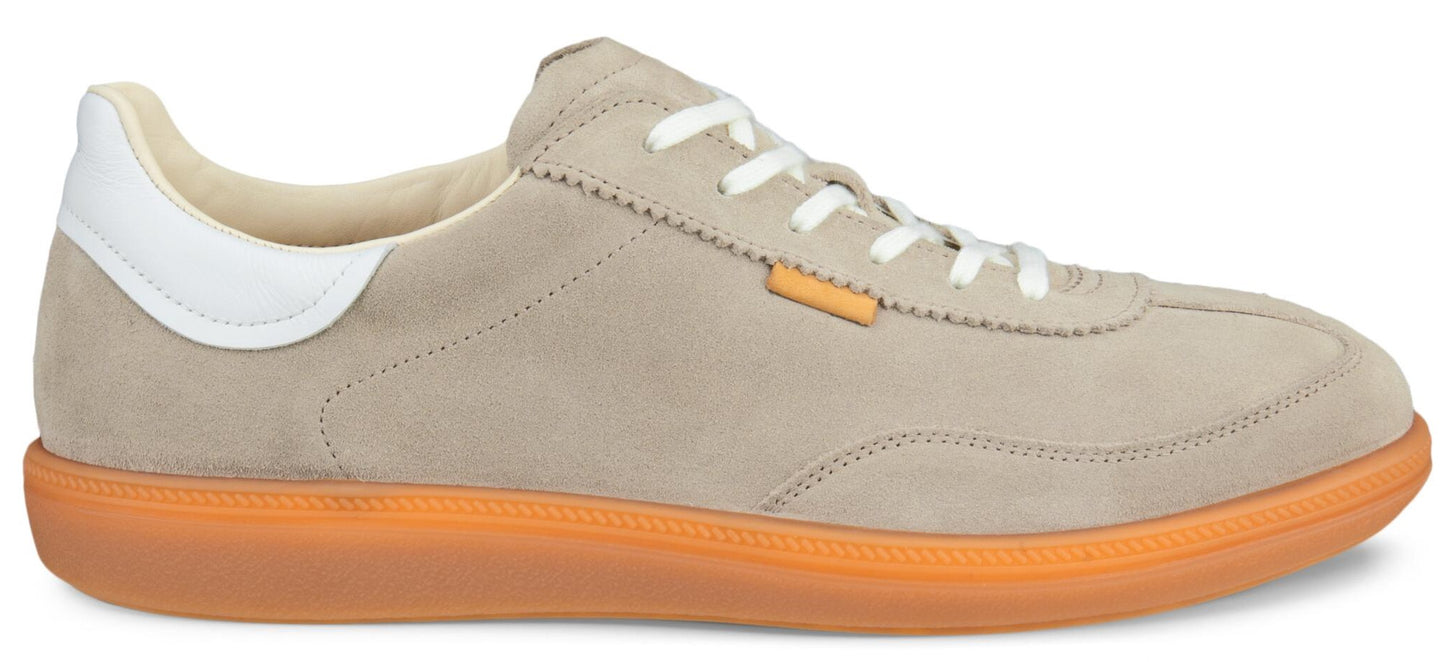 Beige suede sneaker with white accents and an orange sole.