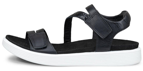 A black sandal with a white sole and velcro straps.