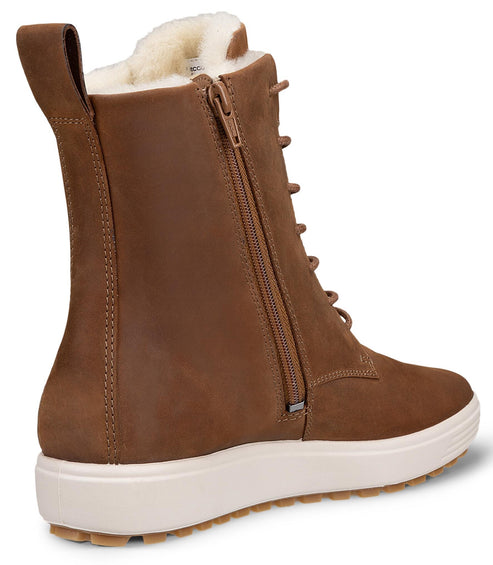 A brown, leather, mid-calf lace-up boot with a thick white sole, a side zipper, and a white faux-fur lining visible at the top, shown from a three-quarter rear perspective.