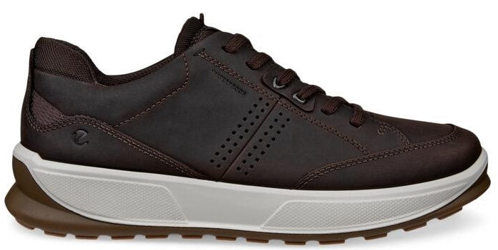 A brown leather walking shoe with a white sole and brown tread.