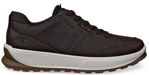 A brown leather walking shoe with a white sole and brown tread.