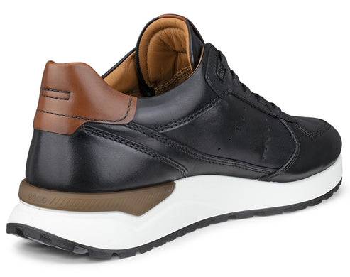 A black leather sneaker with a brown leather heel tab, a thick white midsole, and a brown accent piece on the heel base, viewed from a three-quarter rear angle.