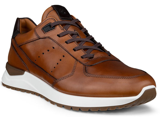A brown leather low-top sneaker featuring dark brown laces, small side perforations, a thick white midsole, and a brown textured outsole.