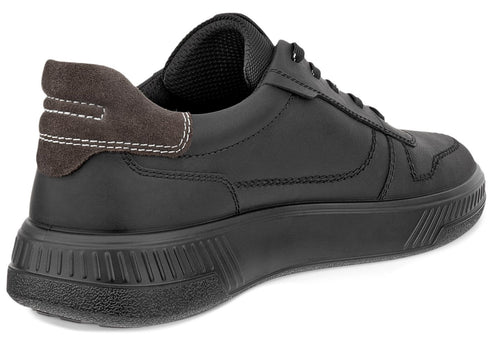A black leather casual sneaker from a rear-angle view, featuring a dark brown suede heel counter with light-colored accent stitching and a thick, ridged black rubber midsole.