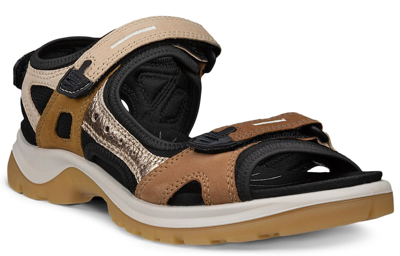 A tan and black sandal with adjustable velcro straps and a thick sole.