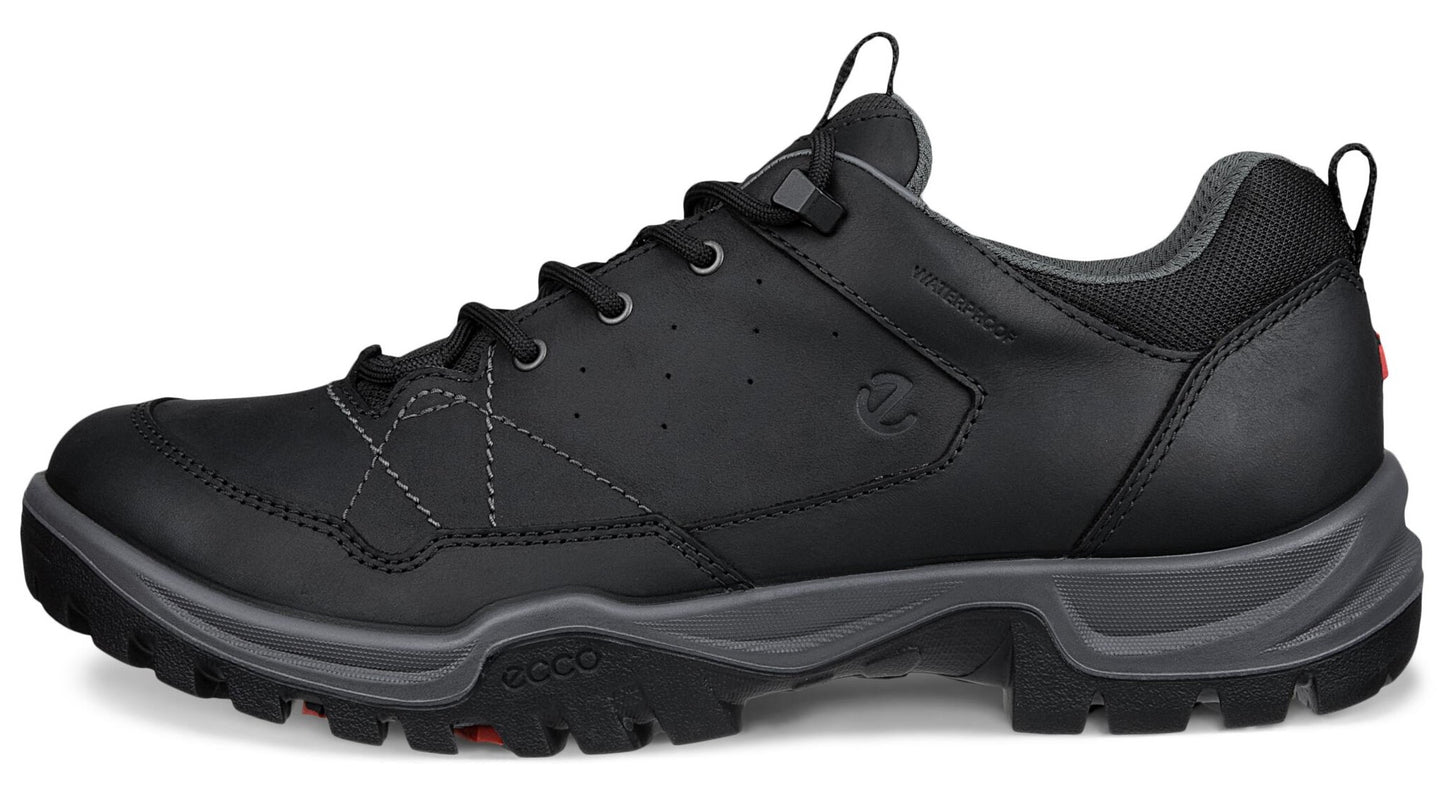 A black men's outdoor shoe with a textured grey midsole, black rugged rubber outsole, black laces, and grey inner lining, featuring a low-top silhouette with a visible brand logo on the side.