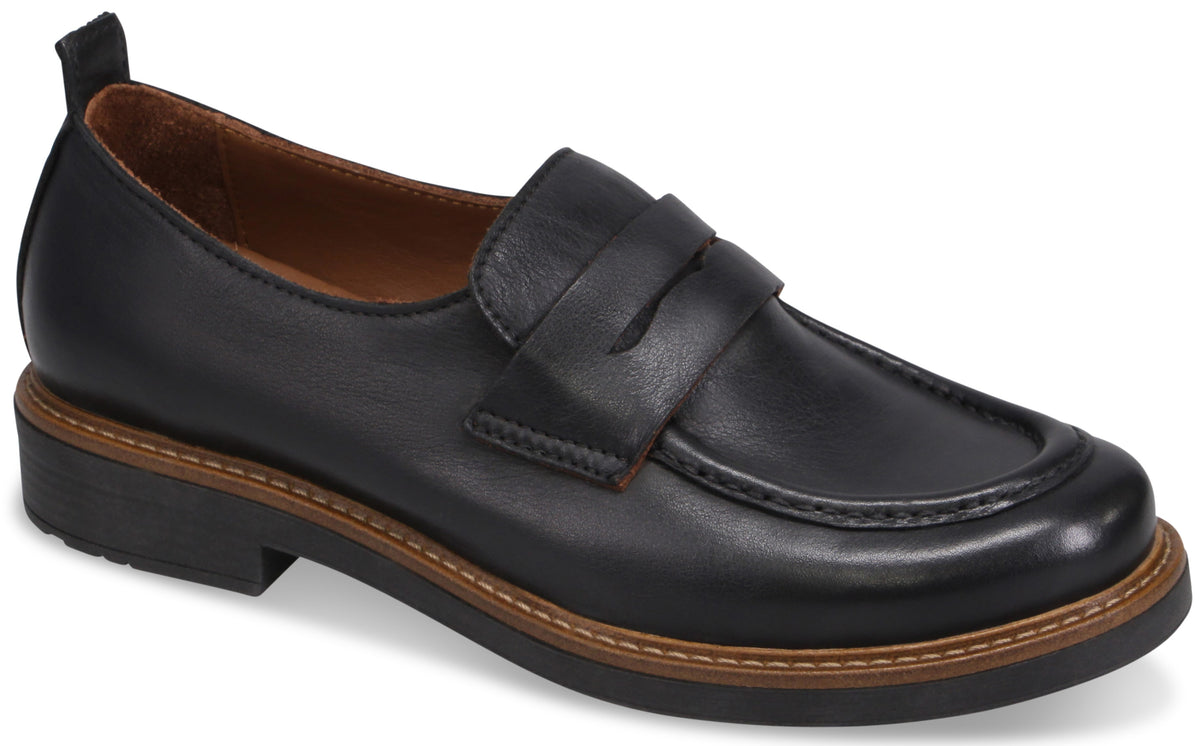A black leather penny loafer with a brown welt and a thick black rubber sole.