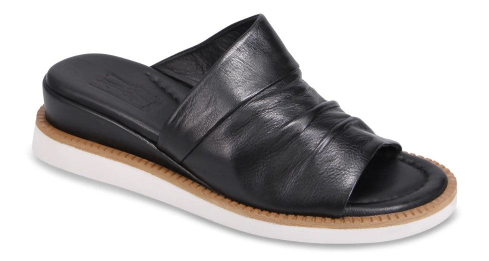 Black leather slide sandal with a low wedge heel and white sole.