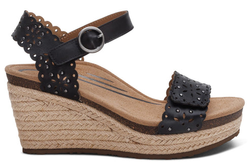 Black wedge sandal with laser cutouts and ankle strap.