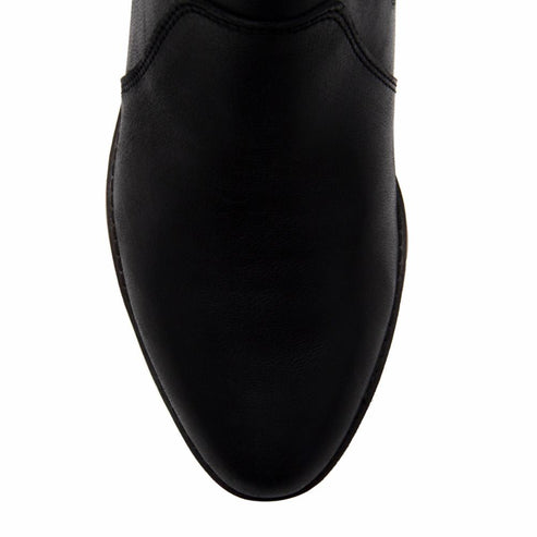 Close-up of a pointed, black boot.