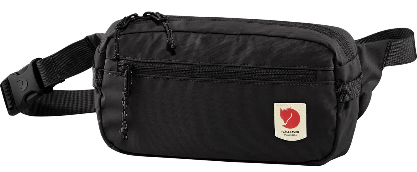 A black fanny pack with a buckle strap and a logo patch.