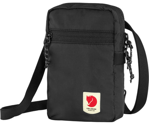Black rectangular bag with shoulder strap, zipper pocket, and a small red patch with a white logo of a fox, and the text "FJALLRAVEN 1960 SWEDEN" below it.