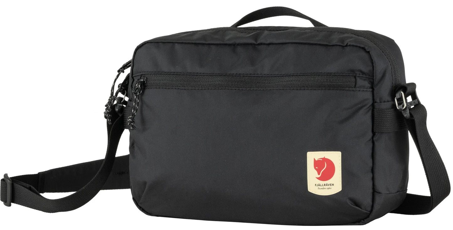 Black rectangular crossbody bag with top handle, zipper pocket, and red and white logo.